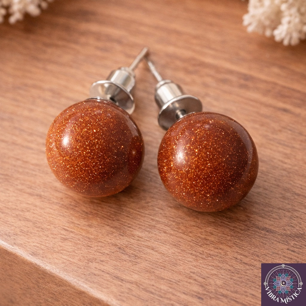 Detalle de aretes con arena dorada roja mostrando tonos naturales vibrantes