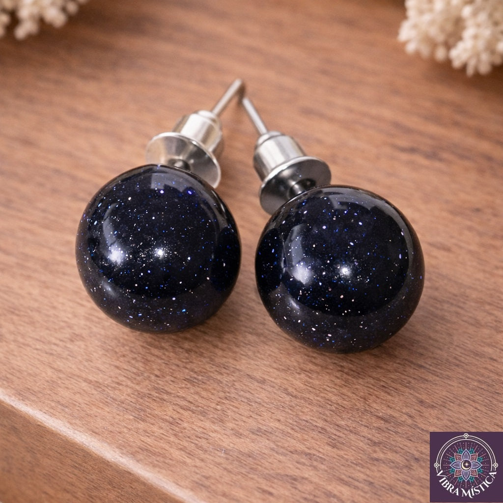 Detalle de aretes con piedra dorada azul mostrando tonos naturales y engaste premium