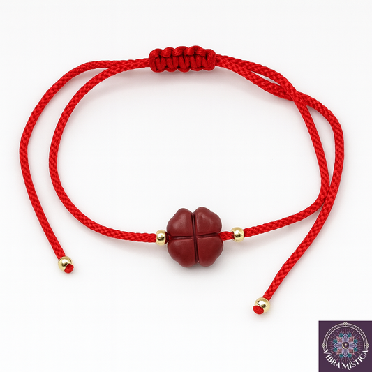 Pulsera trébol de cuatro hojas con cinabrio y cordón rojo sobre fondo blanco